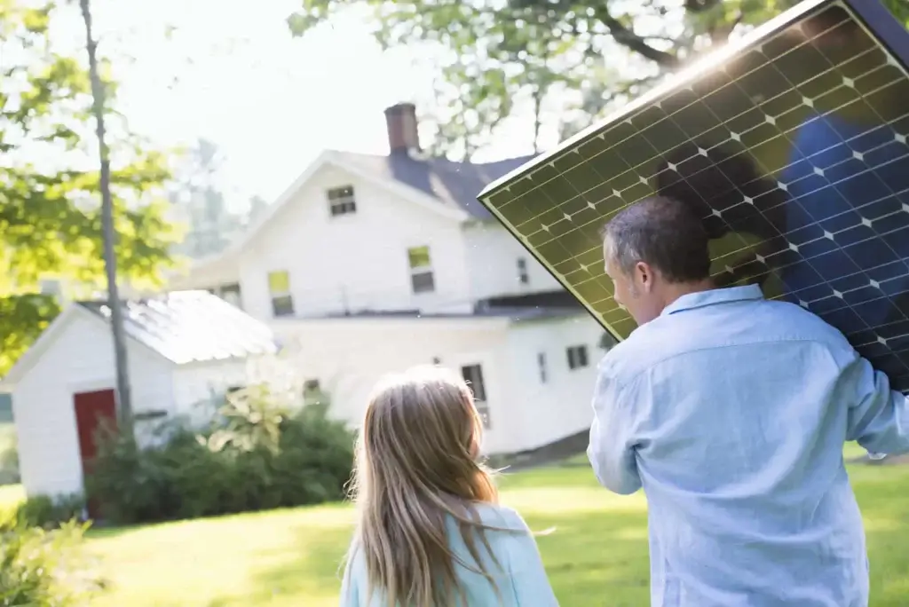hombre e hija con vivienda de placas solares